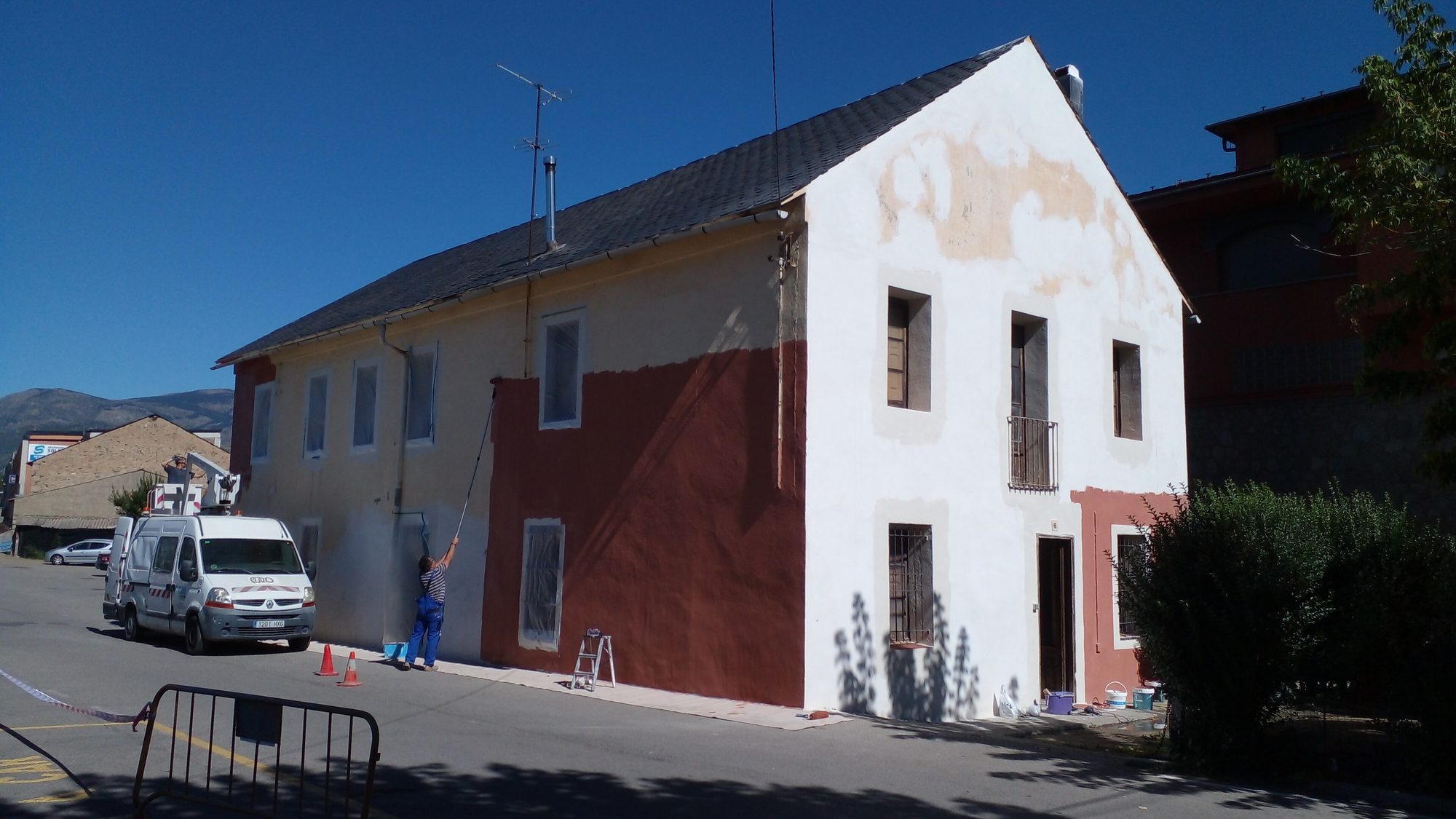 Sobrado com metade da fachada já pintada de branco e a outra metade ainda com a tinta antiga